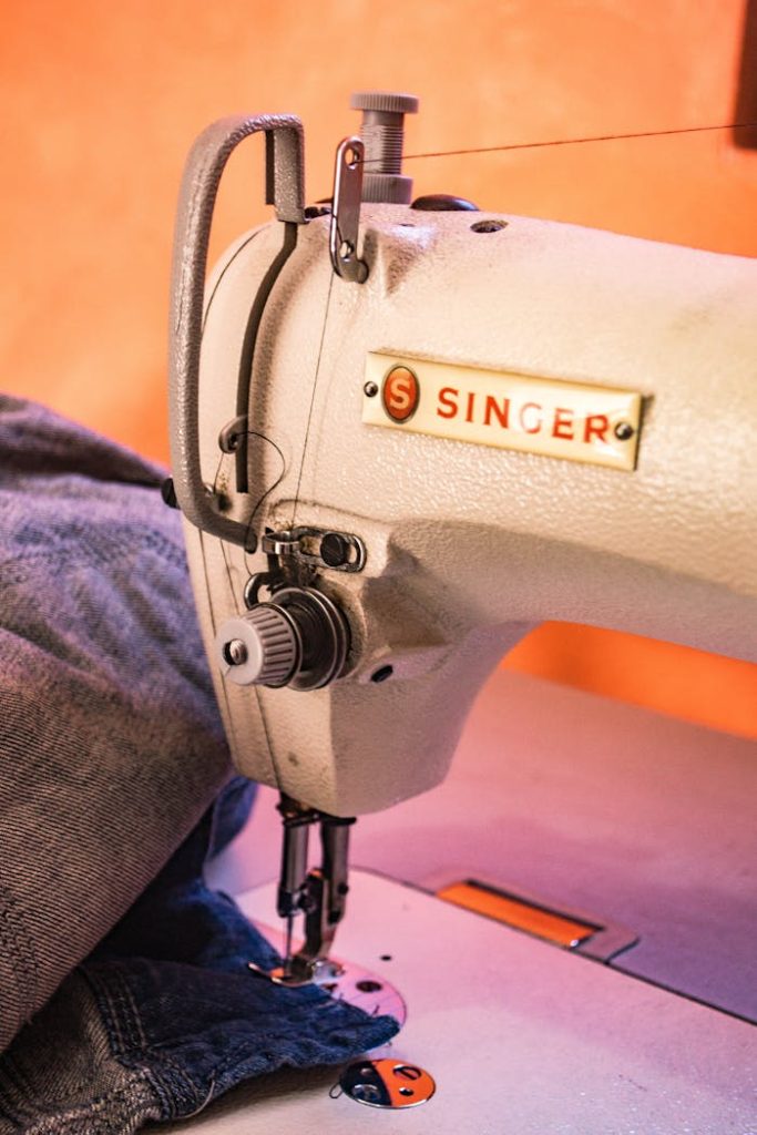 Detailed view of a Singer sewing machine working on denim fabric with precision.
